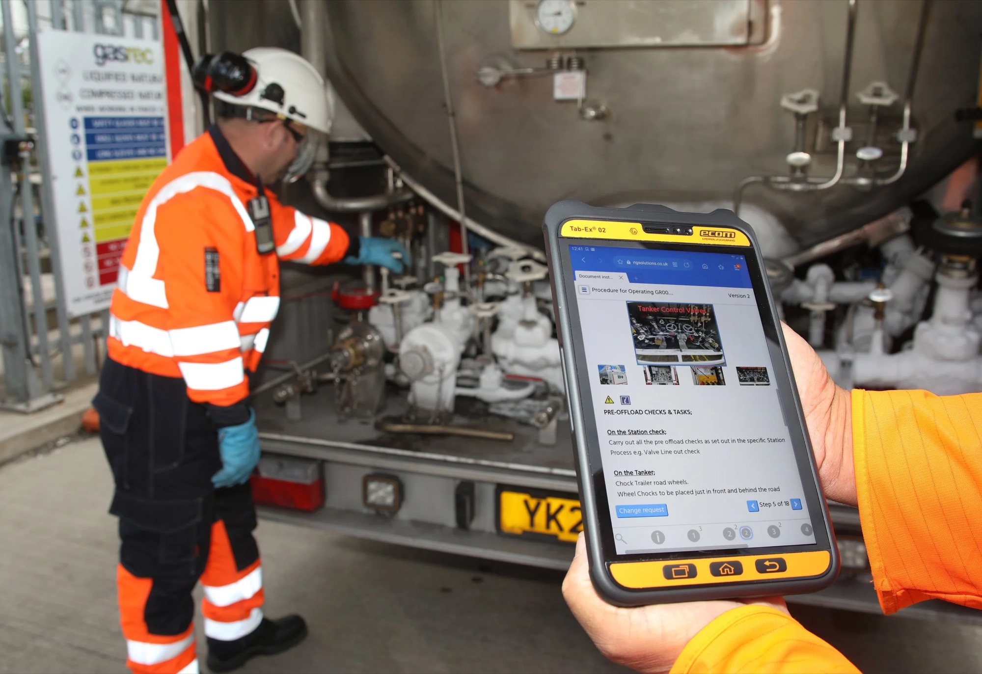 A Gasrec engineer checking a tanker connection with a tablet